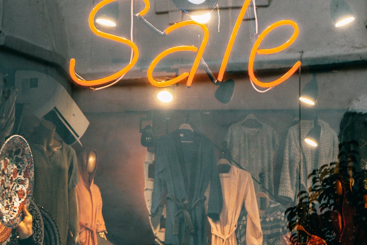 Clothing price tags and sale signage in a menswear store window