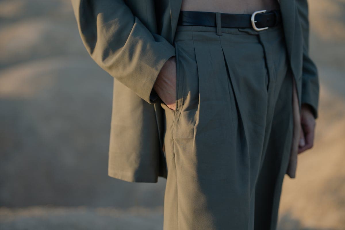 A man in a relaxed soft-structured suit with wide lapels and high-waisted trousers standing in natural light