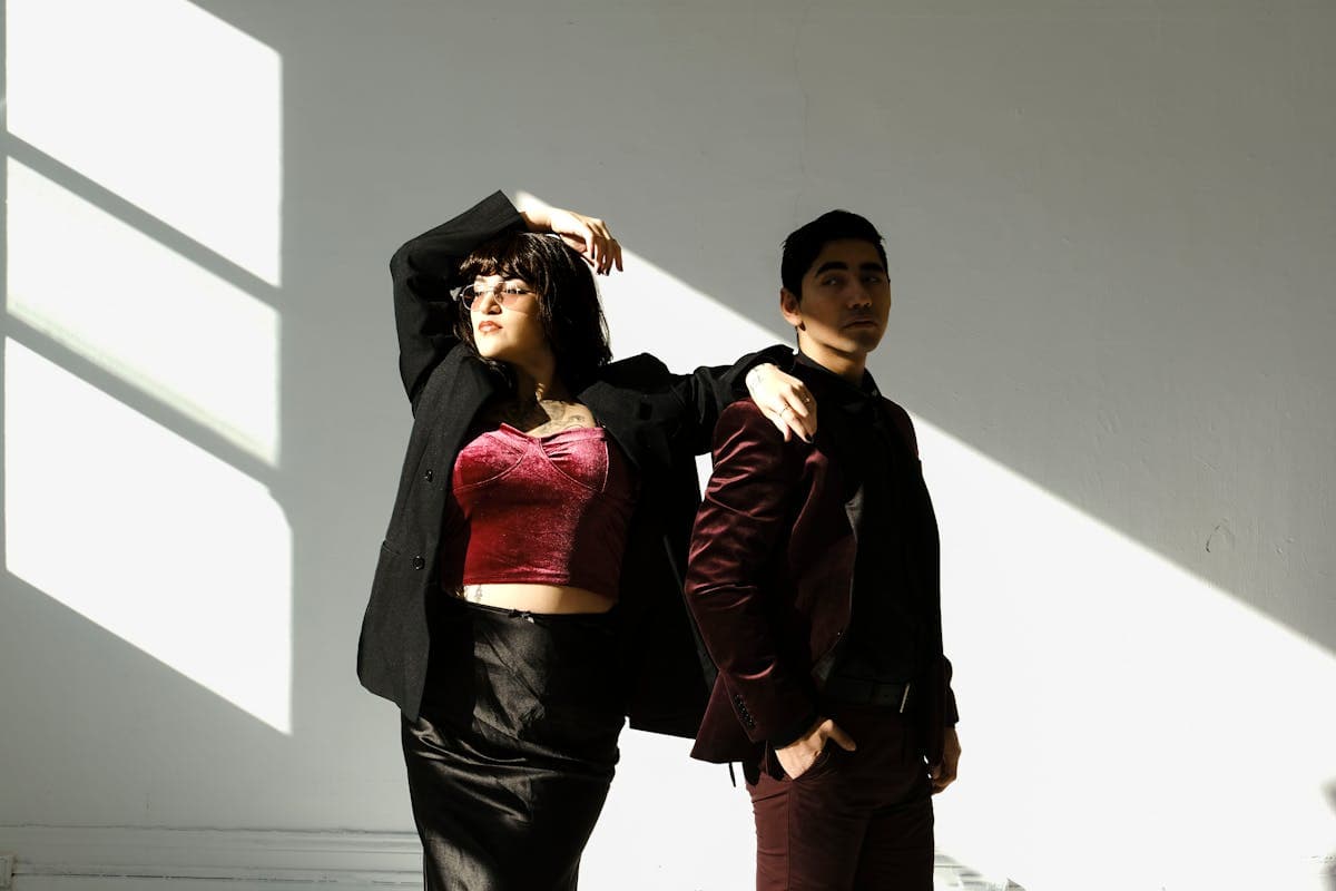 Man in a richly colored velvet or burgundy dinner jacket worn with dark trousers, capturing the bold-color tuxedo look