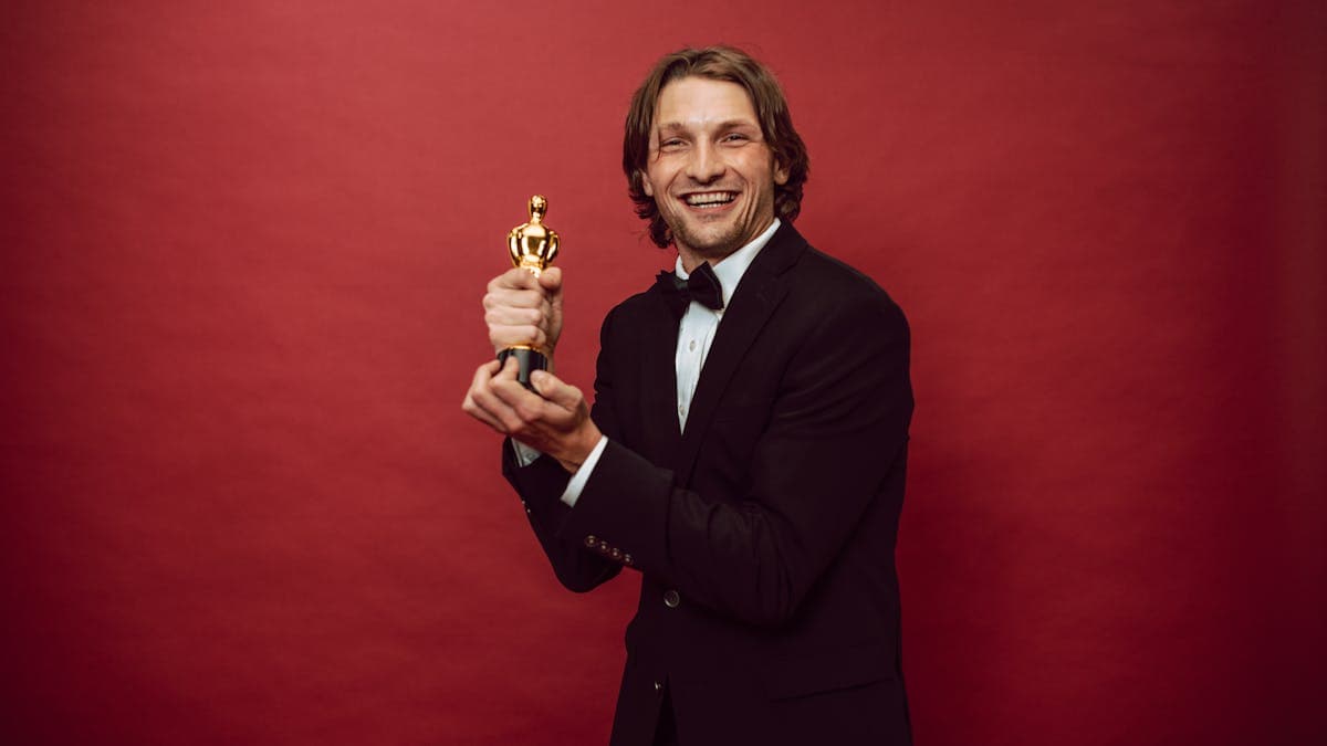 Man in a sharp formal suit against a dramatic red backdrop -- the kind of bold red carpet energy the Met Gala demands