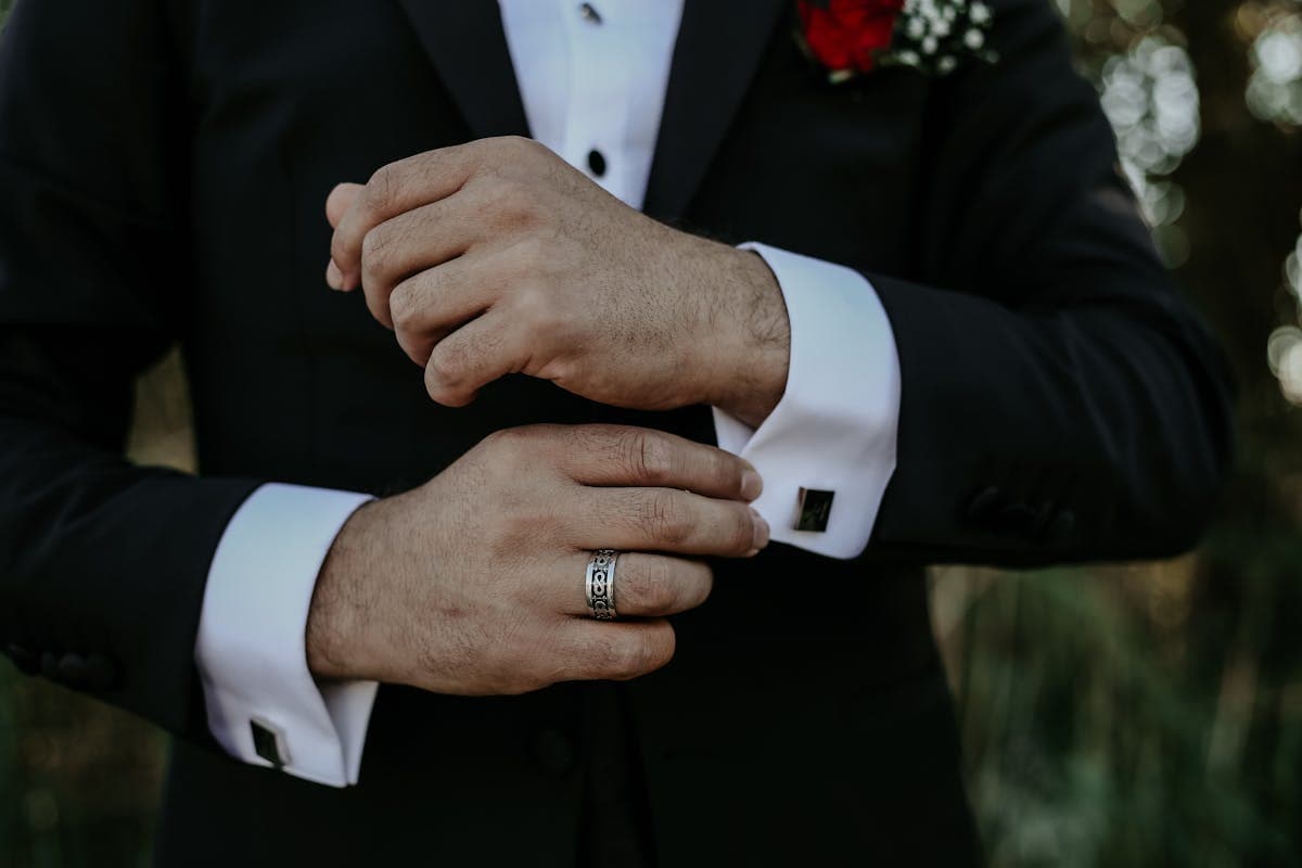 A dark suit sleeve with a red band tied above the elbow against a plain background