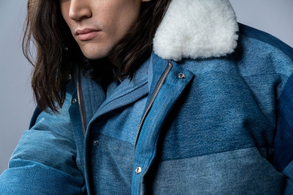 Macro detail of a structured stand-collar band and buttoned placket on a tailored jacket