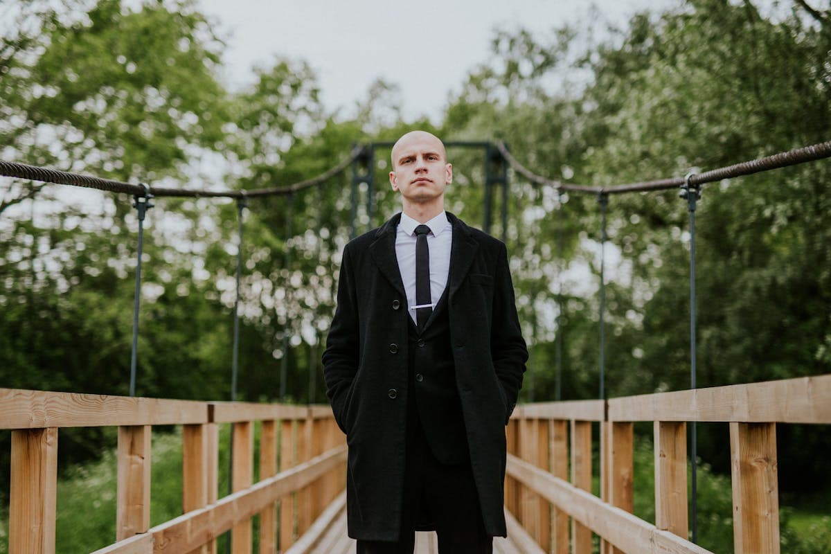 Tall young man in a wide-lapel suit with relaxed shoulders, showing the fuller silhouette trending for 2026