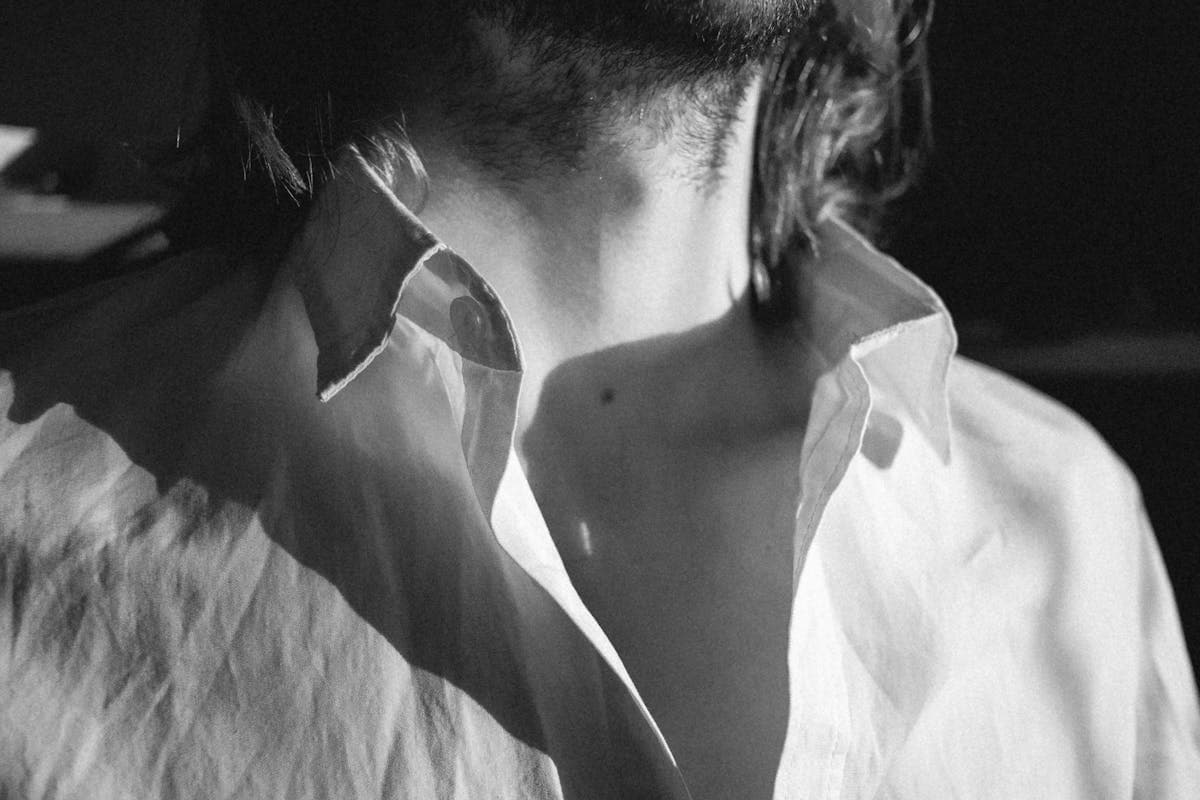 Close-up of a worn white dress shirt collar showing yellowing and fraying at the fold