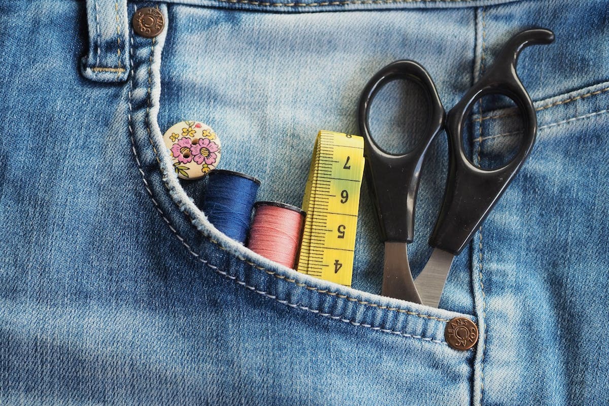 A local tailor pinning the hem of a trouser leg for a small alteration