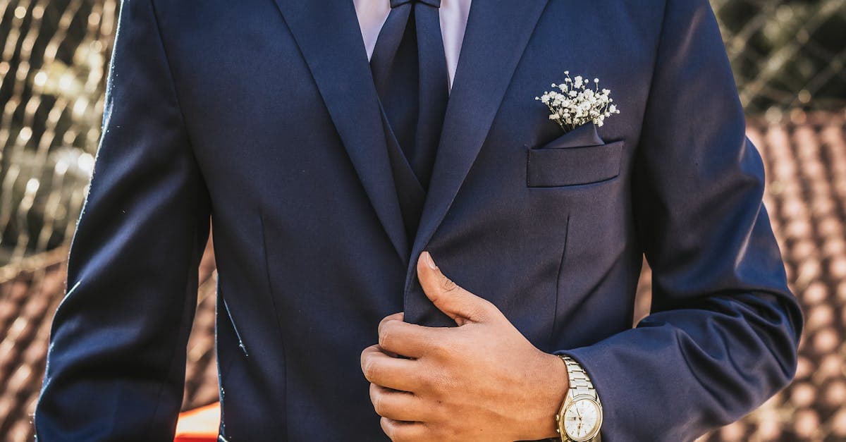 Man in a navy blazer with a yellow pocket square at an outdoor horse racing venue -- the heritage Preakness aesthetic