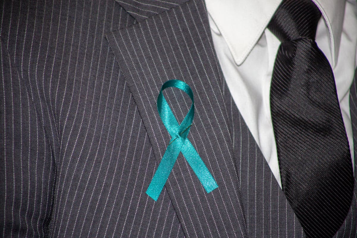 Close-up of a suit jacket collar and lapel sitting against a shirt collar at the back of the neck
