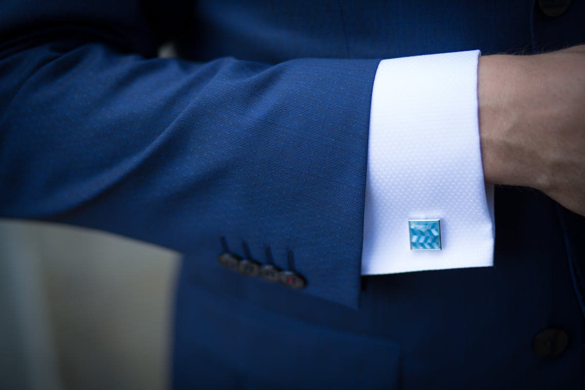 Close-up of a suit jacket sleeve revealing a sliver of shirt cuff at the wrist