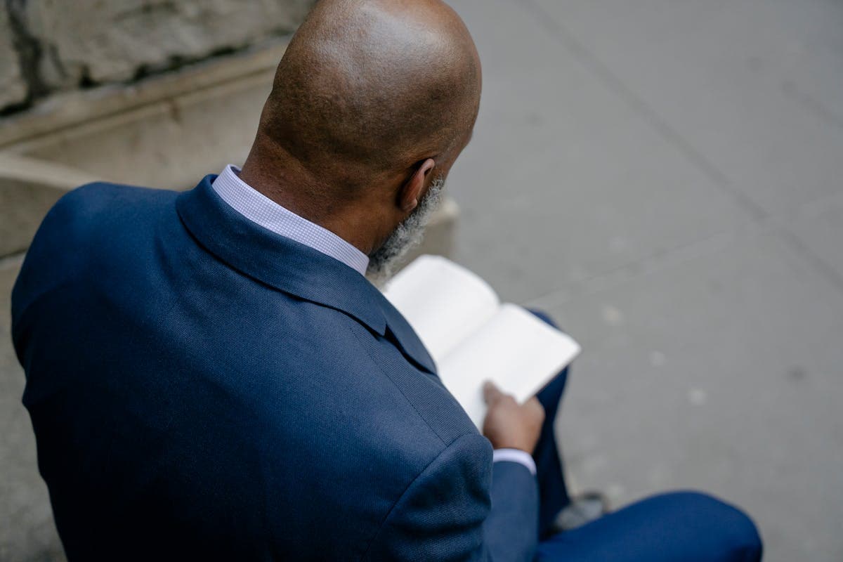 Rear view of a man's suit jacket across the shoulders and upper back, the area where posture and shoulder fit problems show up