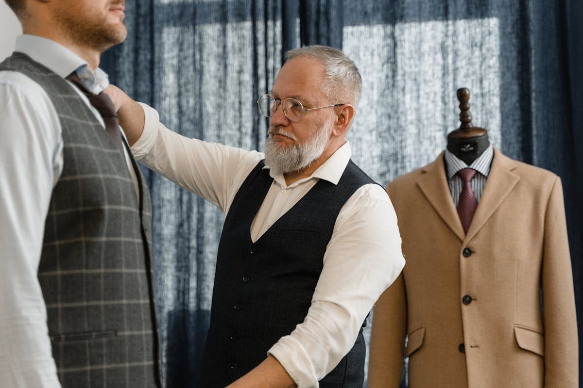 Tailor taking precise measurements of shirt fabric with measuring tape
