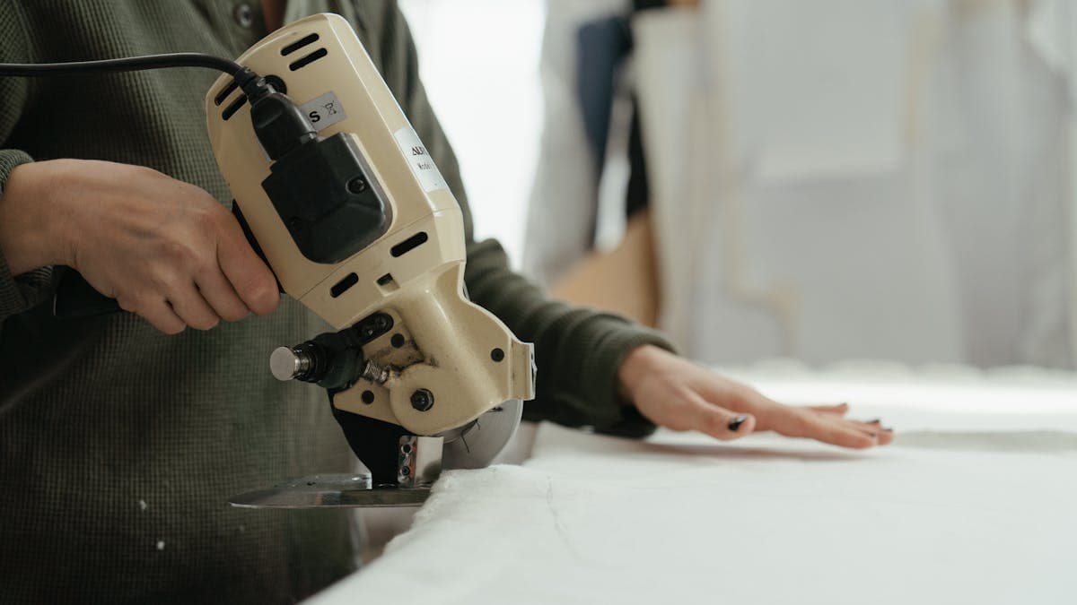 Tailor in a workshop carefully sewing a suit jacket by hand