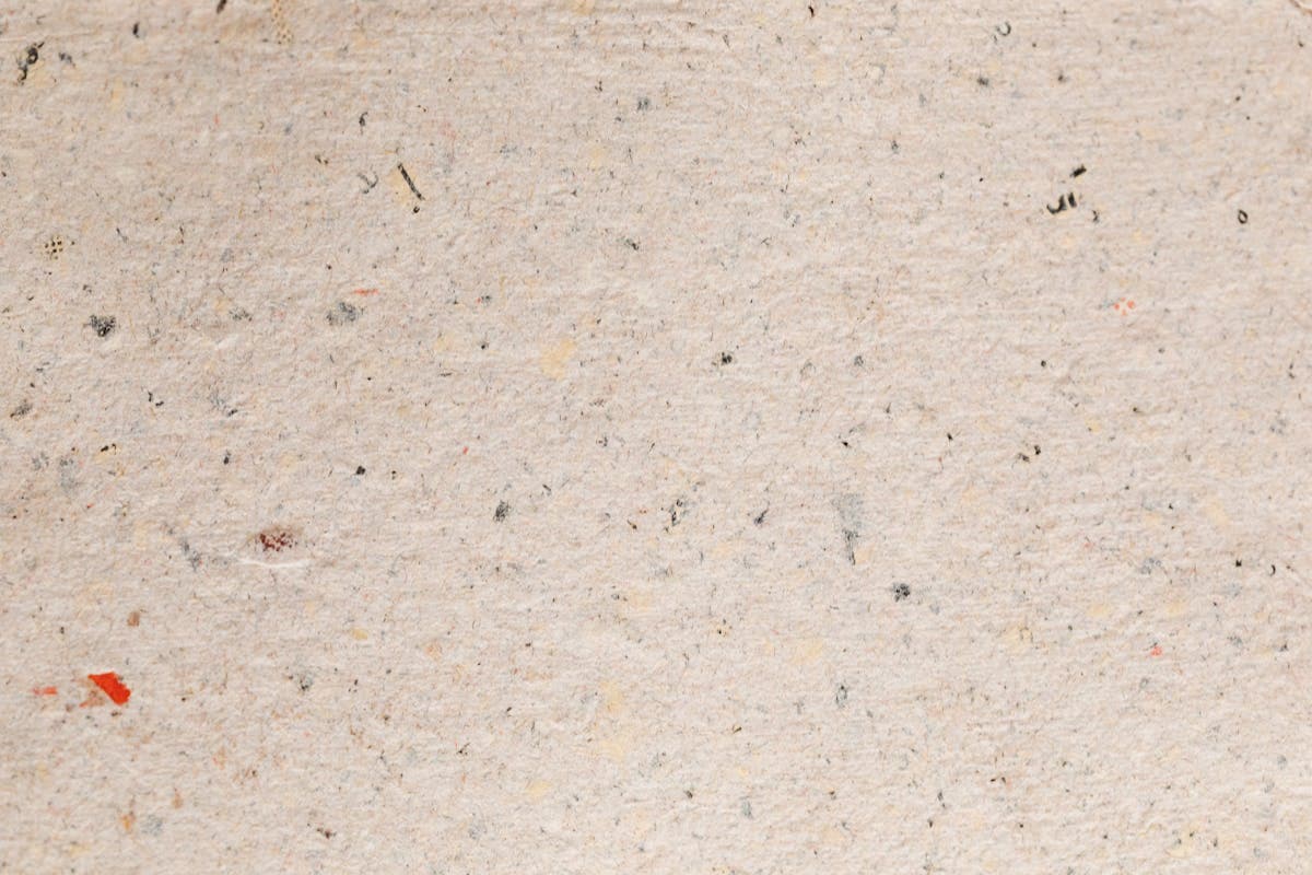 Stacked swatches of textured suiting cloth including flecked tweed and rumpled linen, the fabric textures the model rendered convincingly when given weight and weave