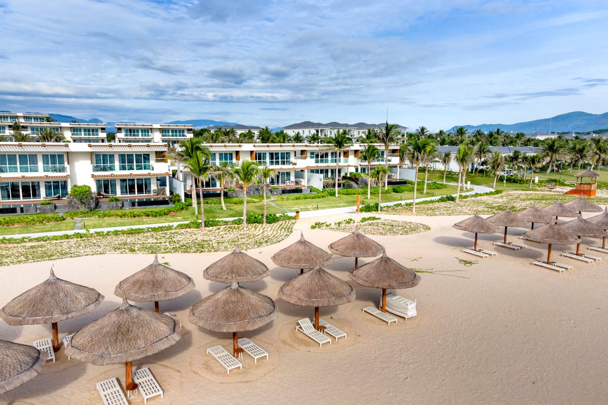 Sun loungers and palm-shaded beachfront restaurants on the sand at An Bang Beach near Hoi An