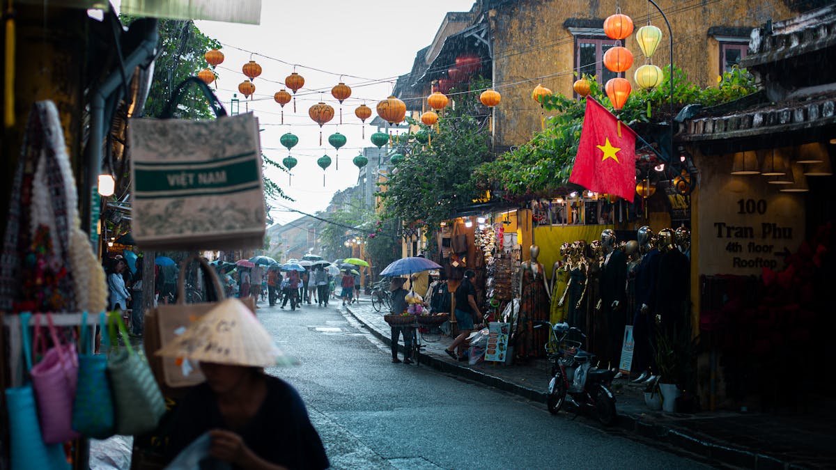 Lantern-lit streets of Hoi An Old Town at dusk with colorful silk lanterns reflecting off the Thu Bon River