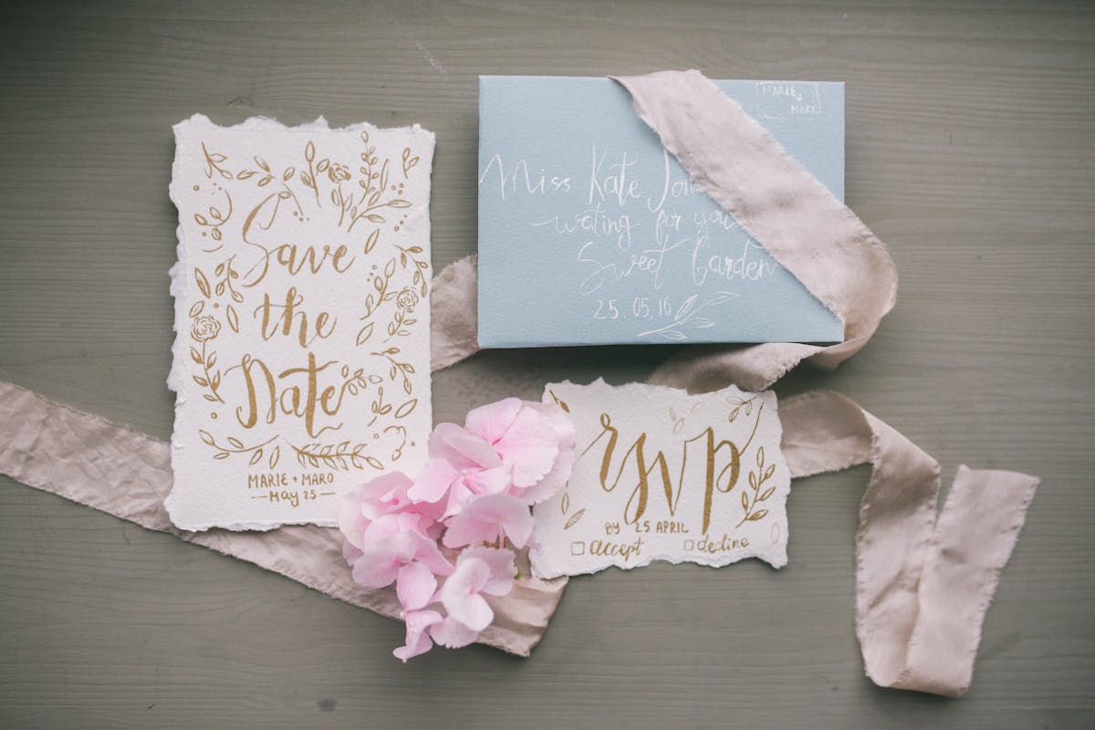 Elegant wedding invitation suite with envelope and calligraphy laid on a neutral table