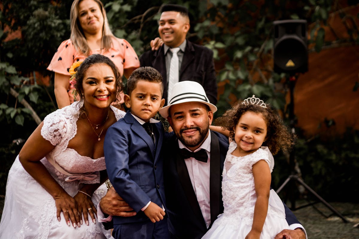A multi-generation family standing together in coordinated dark suits and tasteful dresses at a formal celebration