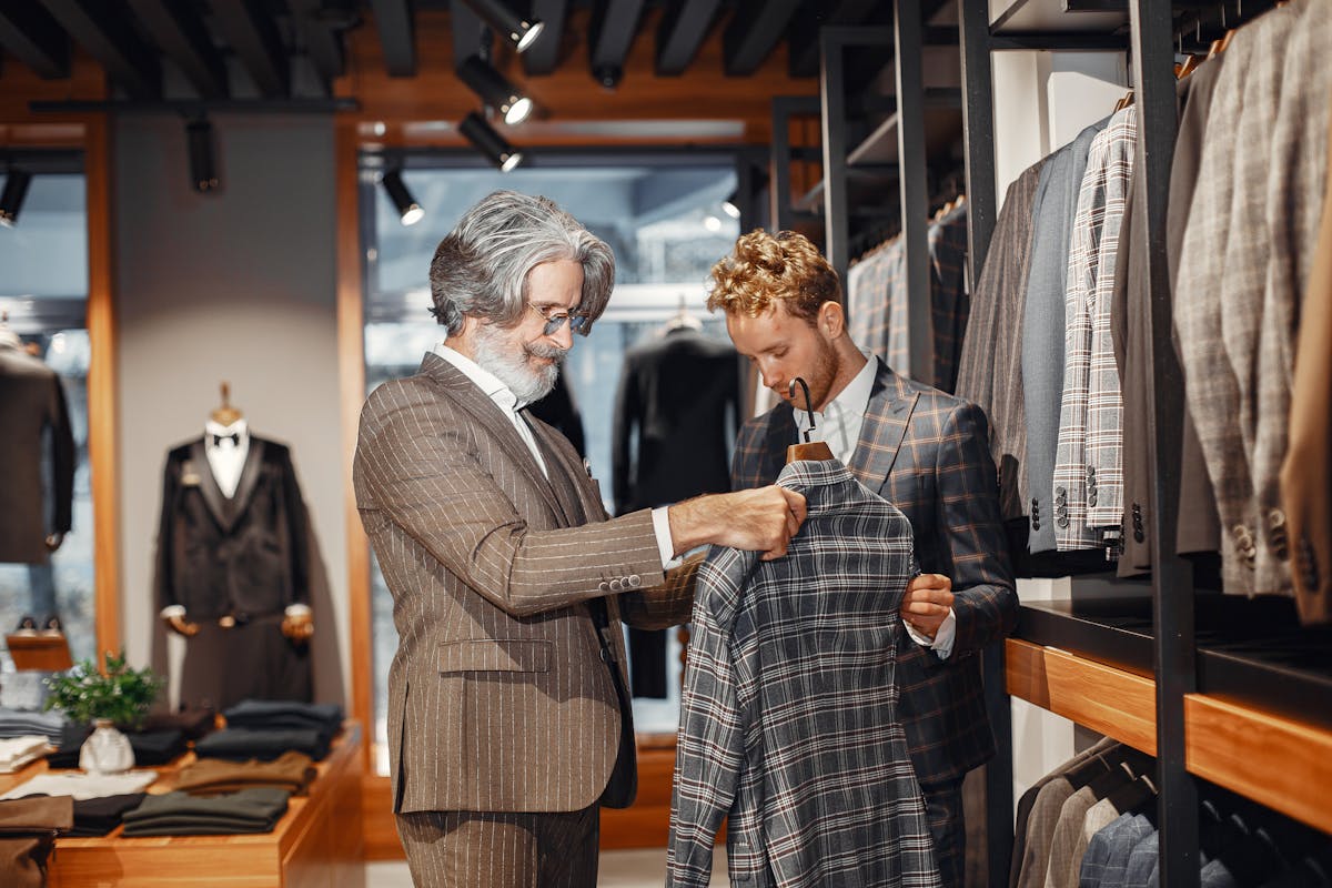 Row of off-the-rack suits in neutral colors hanging in a department store
