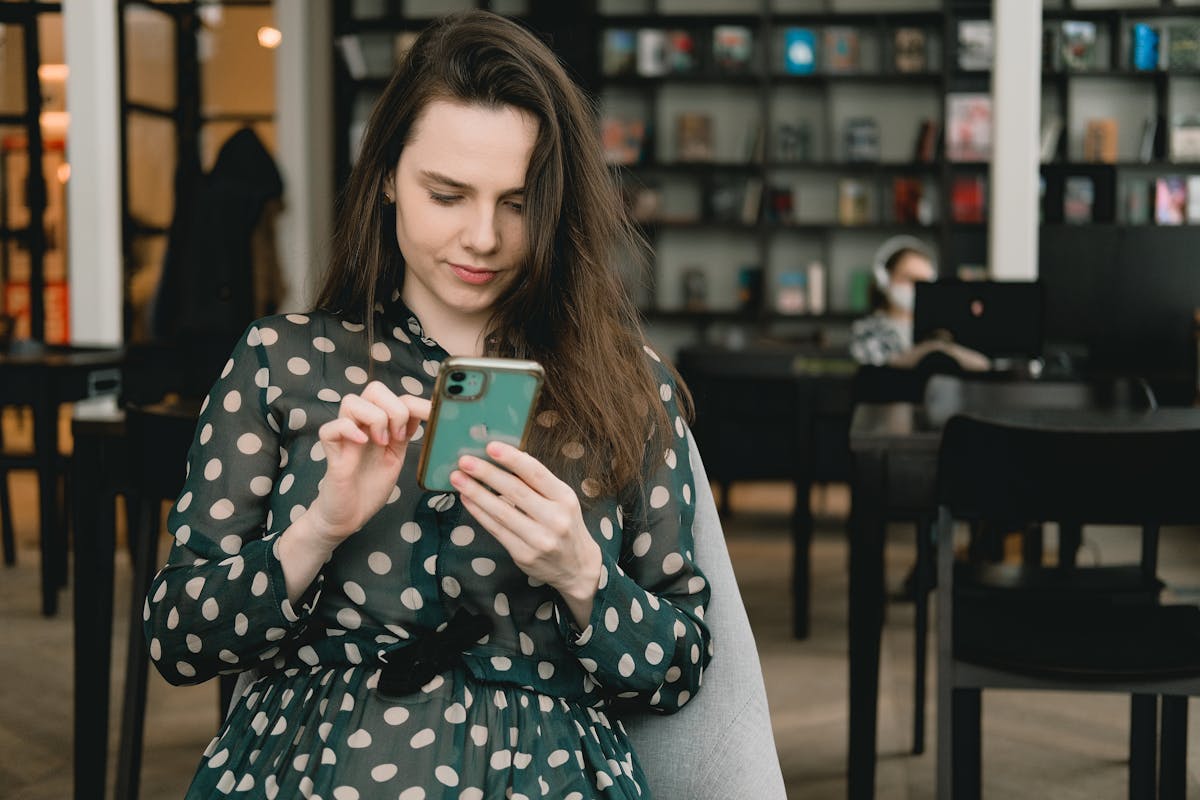 Woman browsing dress inspiration photos on a phone and tablet beside fabric swatches