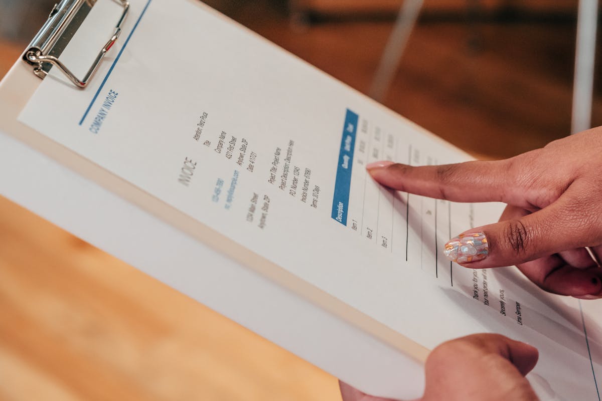 Person reviewing an itemized price quote with a pen, checking line items