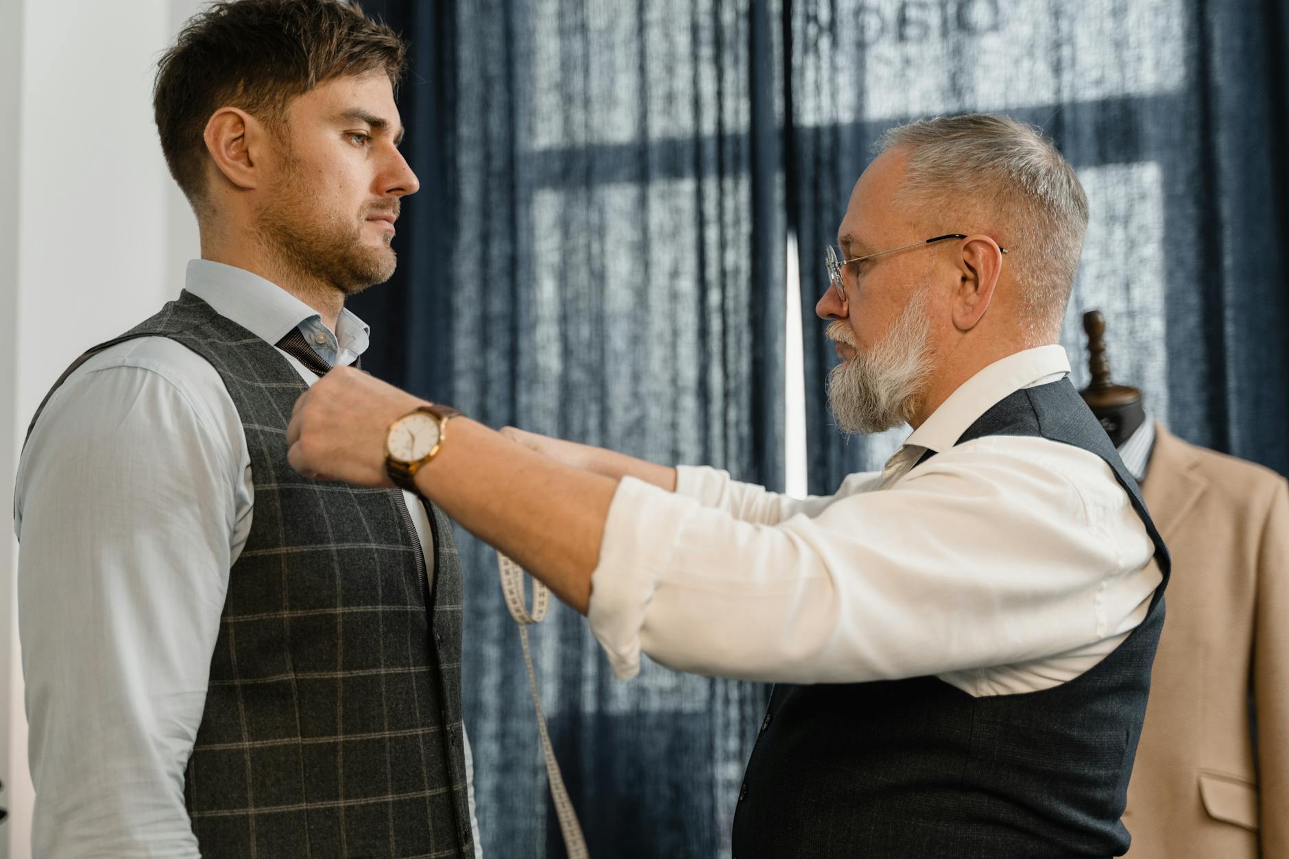 Tailor measuring a groom for a custom wedding suit fitting