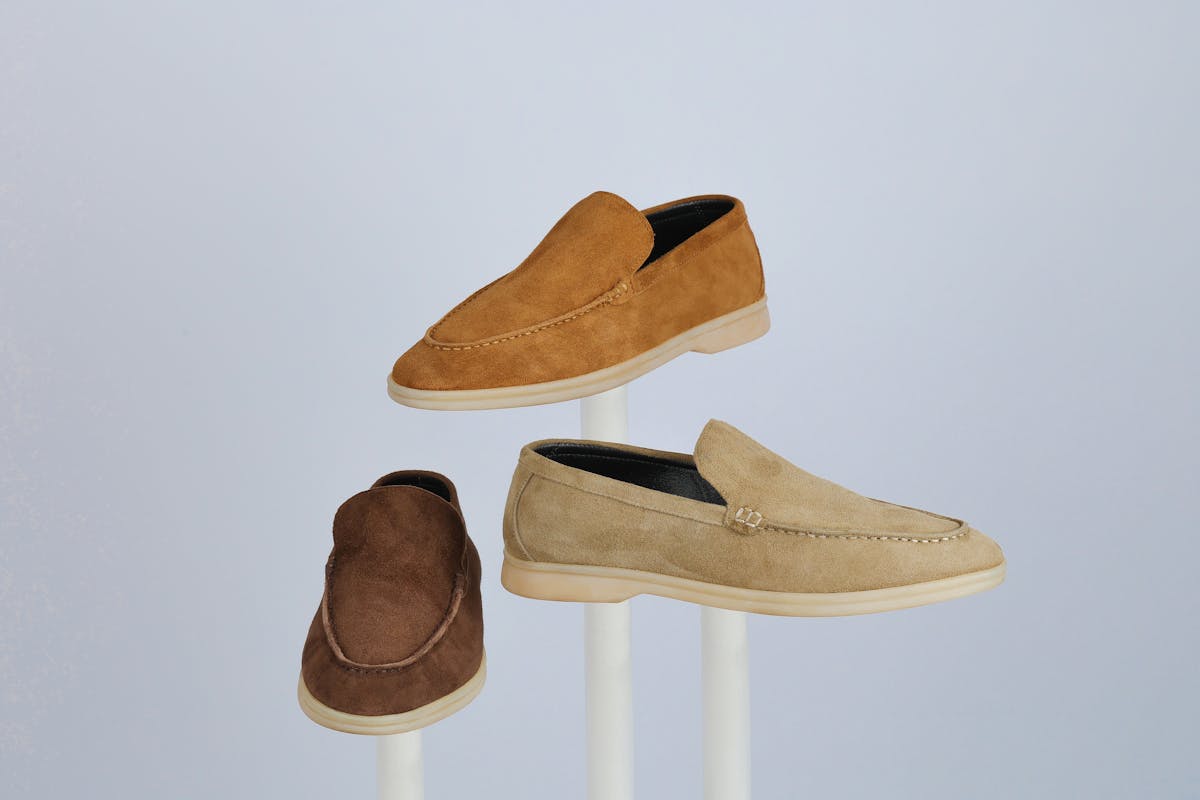Tan suede loafers and brown leather boots arranged for a warm-weather wedding