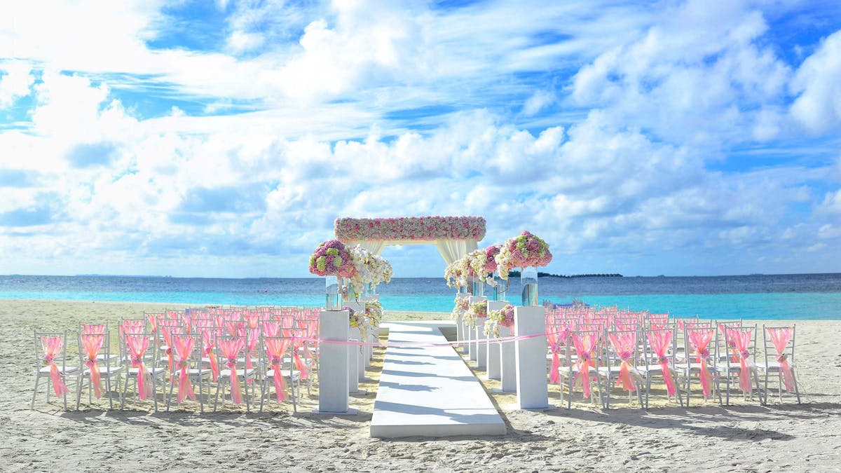 Coastal ceremony setup on a beach in central Vietnam with lanterns and tropical greenery -- the kind of destination wedding setting that costs a fraction of what it would back home