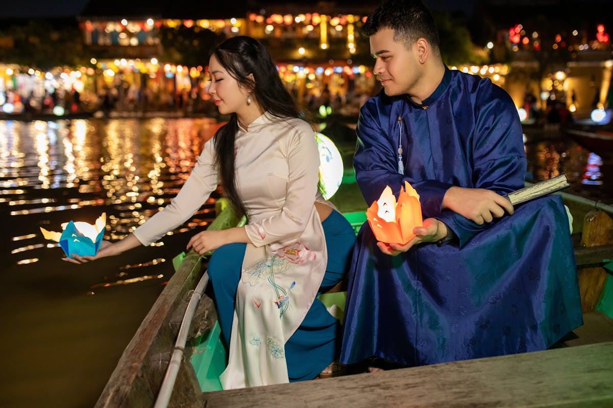 Hoi An Ancient Town at dusk with silk lanterns glowing over the Thu Bon River and yellow shophouse walls -- the central Vietnam backdrop couples choose for destination weddings