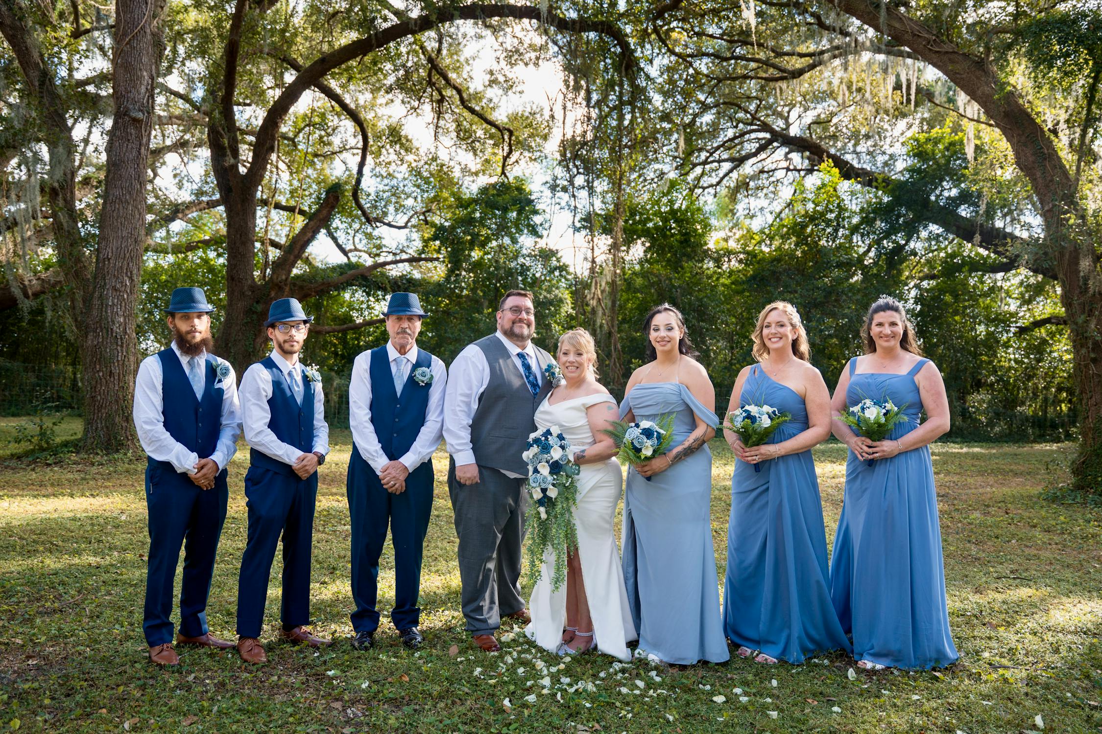 Wedding party in coordinated custom attire posing together outdoors