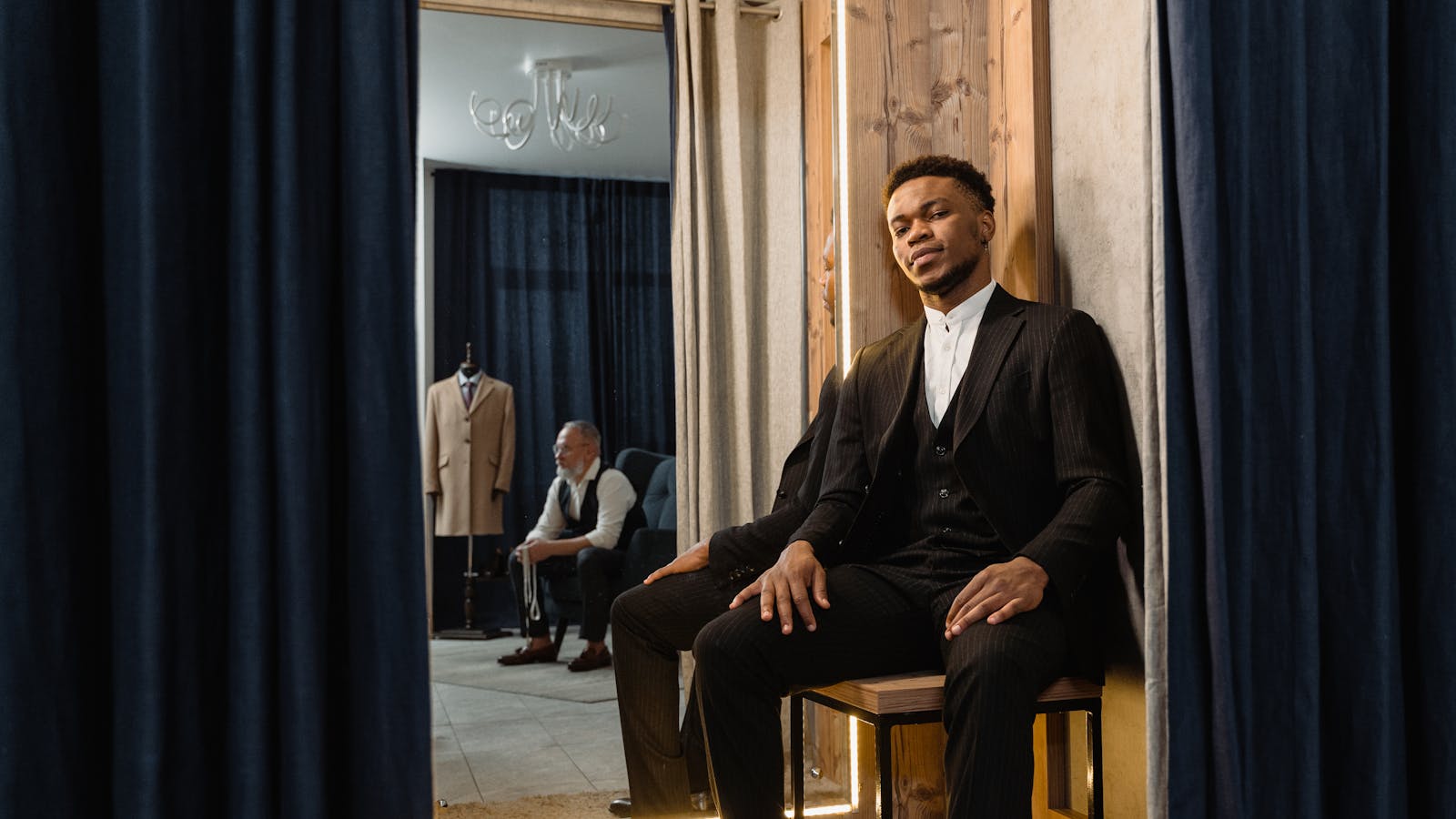 A young adult in a sharply tailored suit shot in moody low light -- the grown-up aesthetic Euphoria Season 3 is leaning into