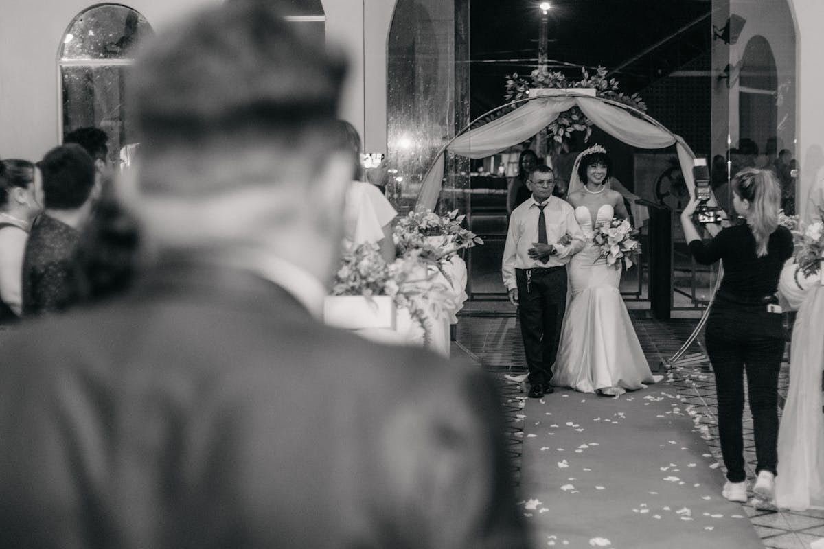 Father of the bride walking his daughter down the aisle in a tailored suit