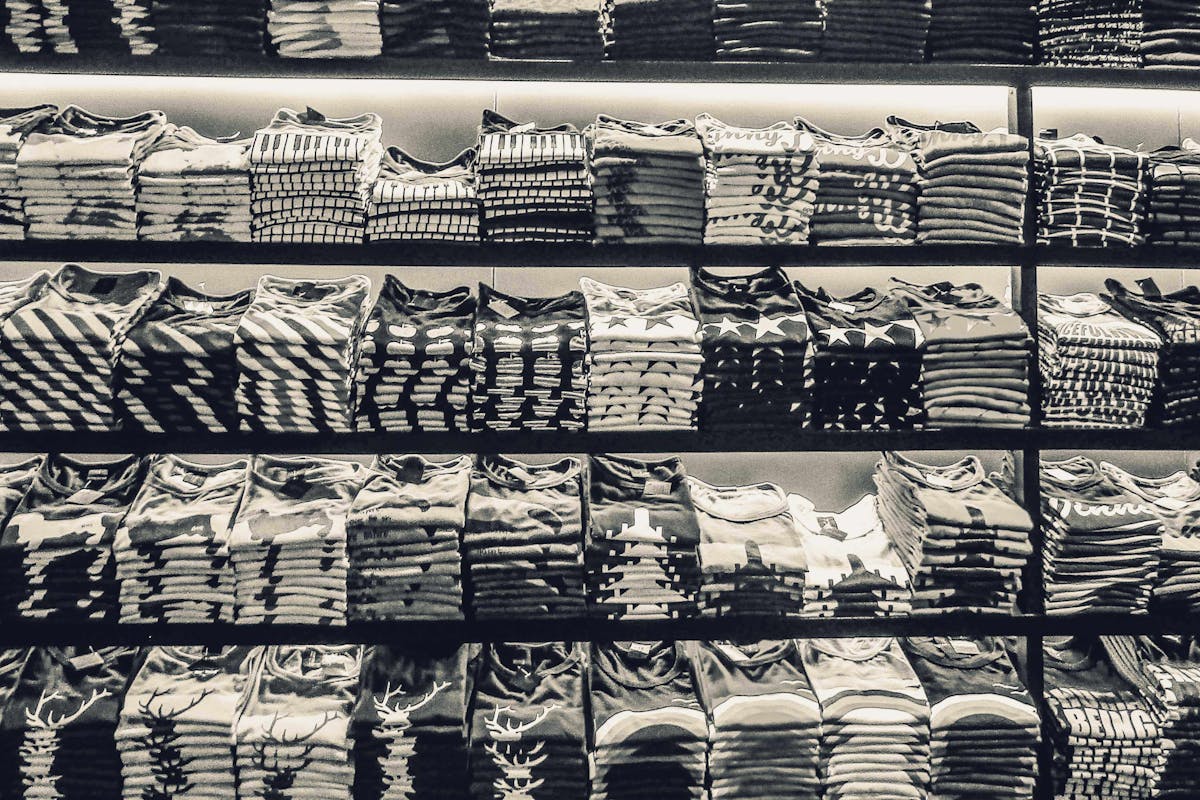 Stack of crisp folded custom dress shirts in cotton, the recommended first order for a Hoi An tailor first-timer