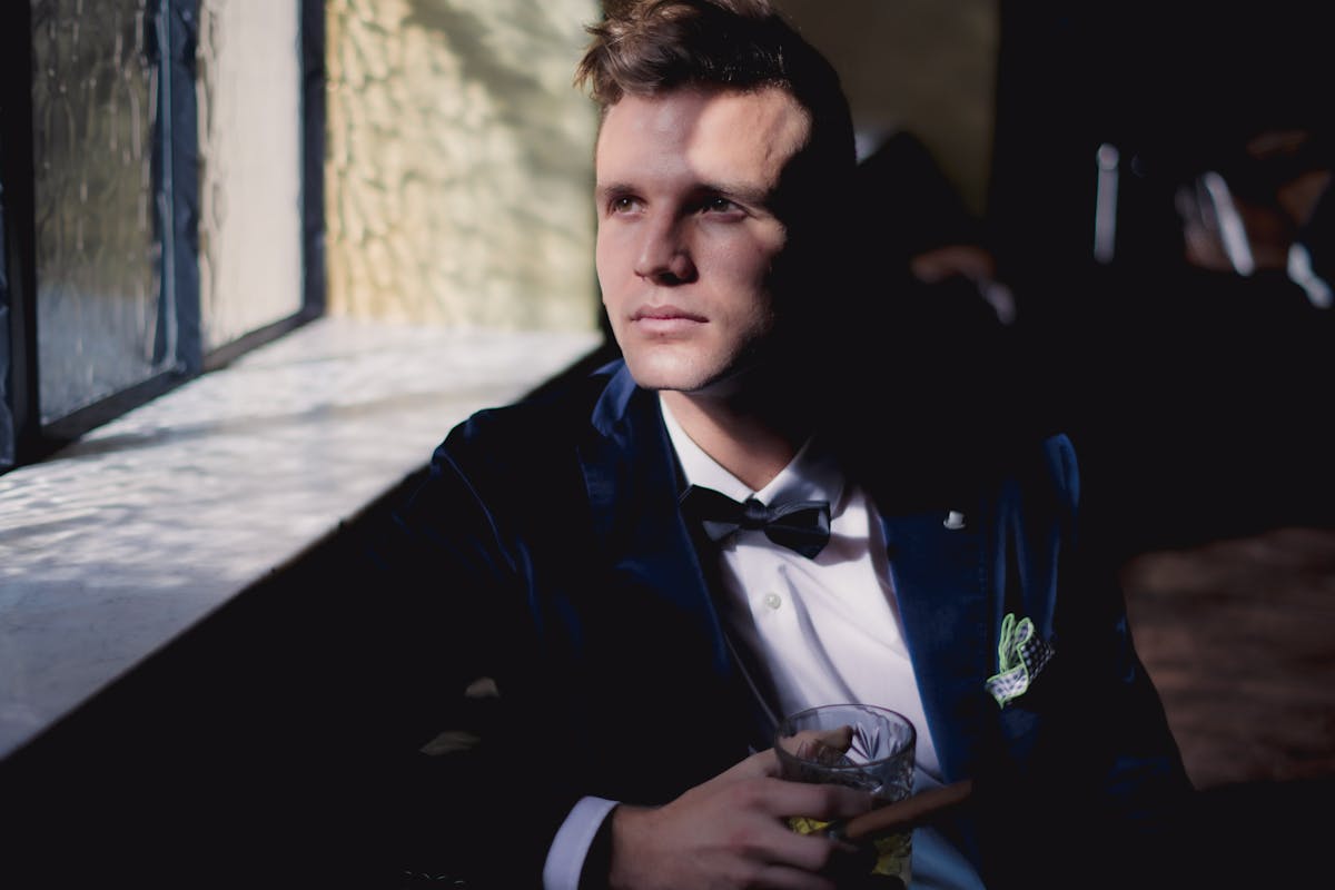 Emerald green velvet suit jacket with wide peak lapels photographed in soft studio light, evoking a Hoi An custom tailor's Grammy-inspired look