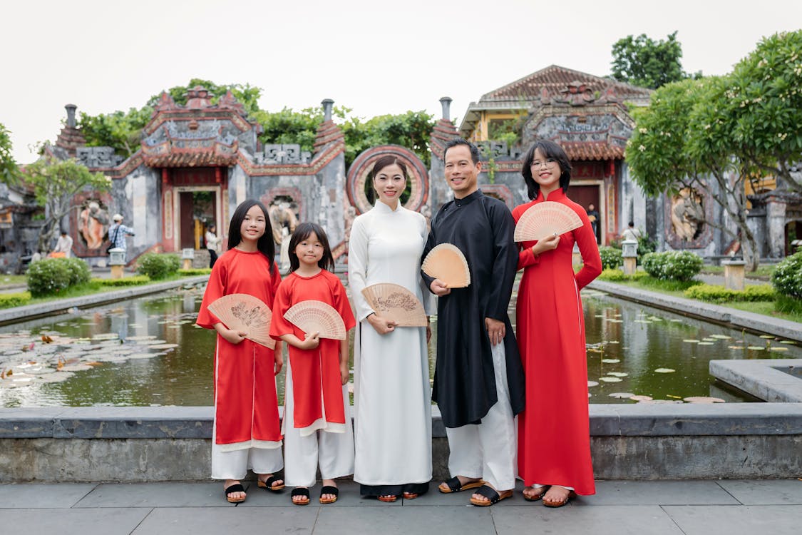 Family walking through the ancient streets of Hoi An, Vietnam, with yellow walls and colorful lanterns overhead