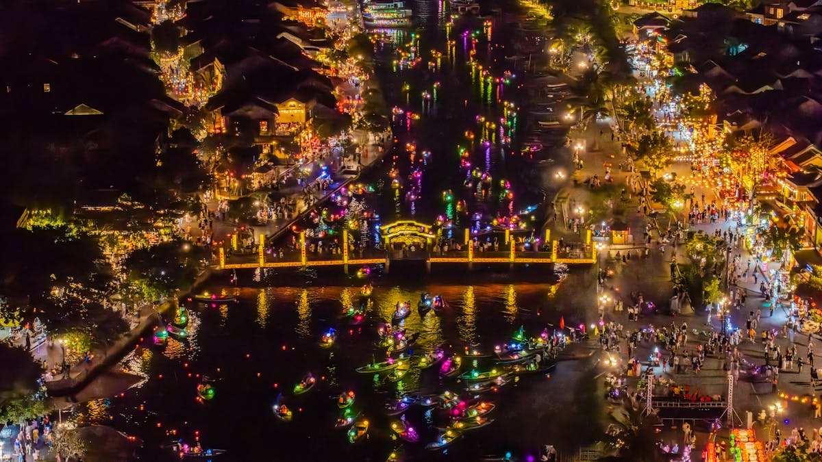 Couple walking hand in hand through the lantern-lit streets of Hoi An Old Town at dusk