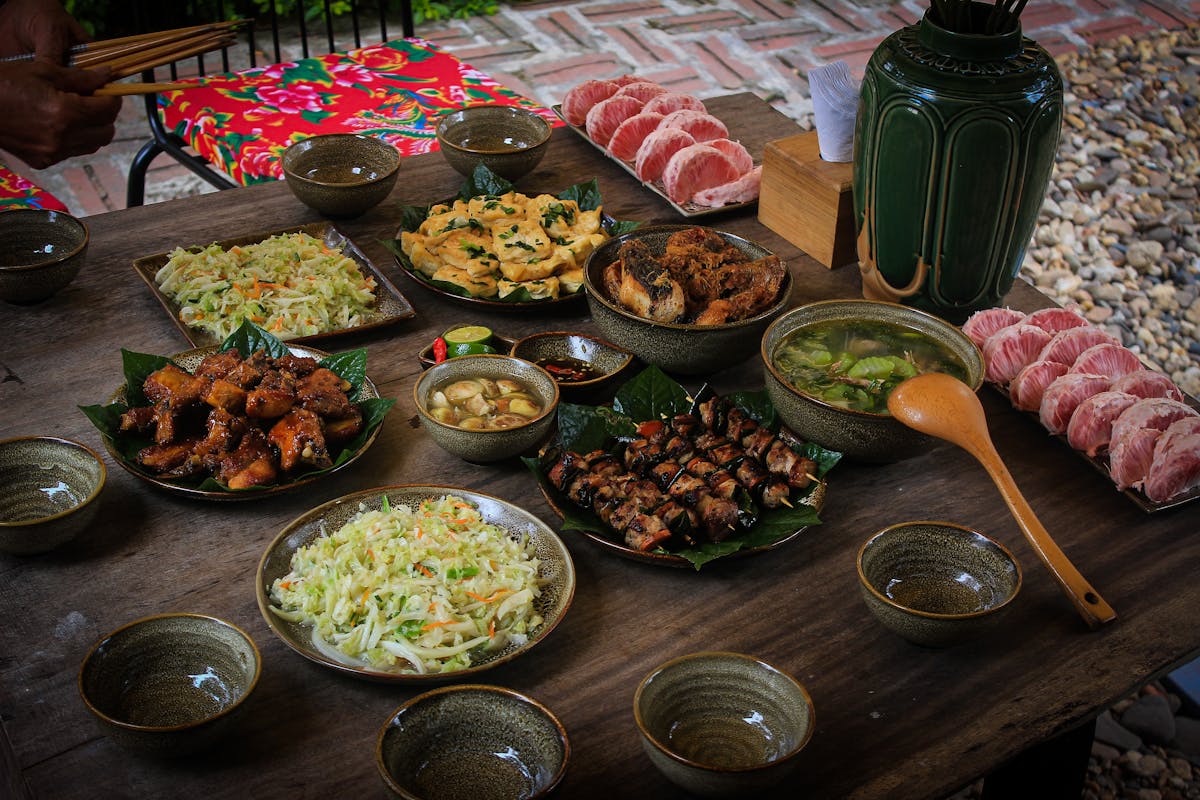 A spread of Vietnamese dishes shared family-style on a table, including spring rolls and noodle bowls