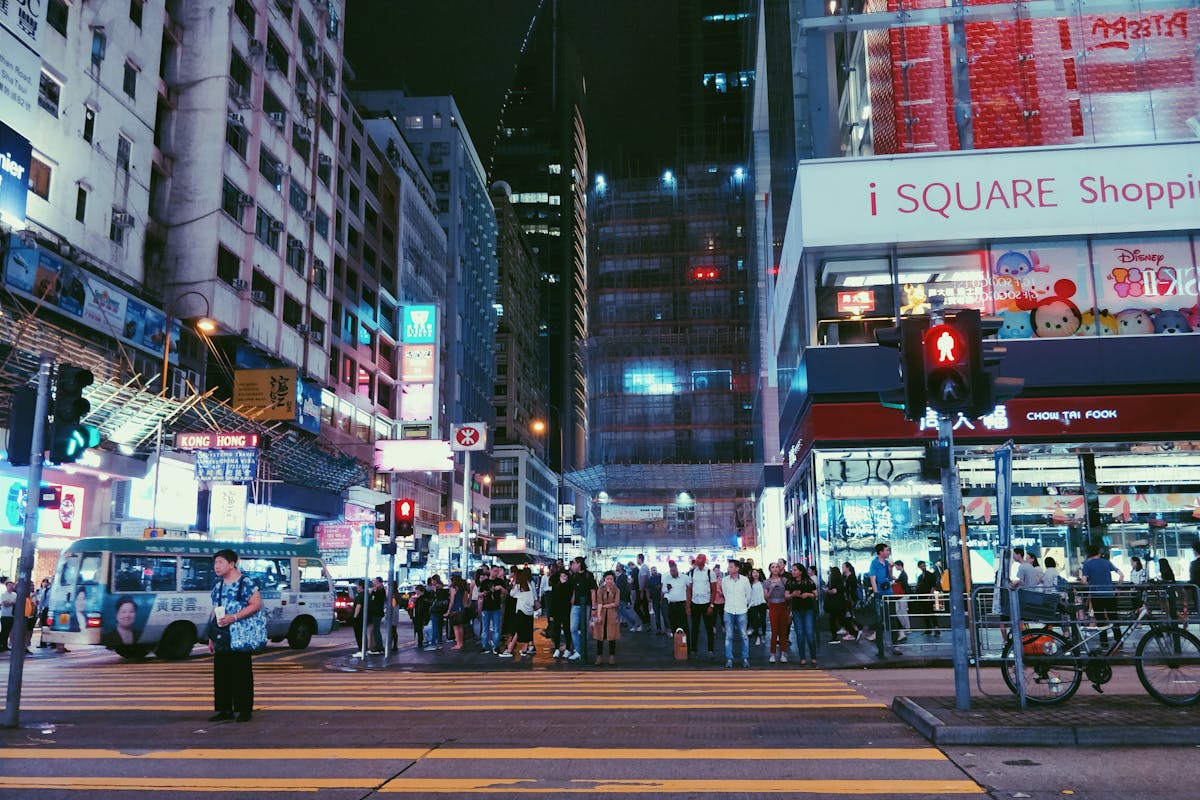 Neon shop signs and crowded streets of Tsim Sha Tsui in Hong Kong at dusk