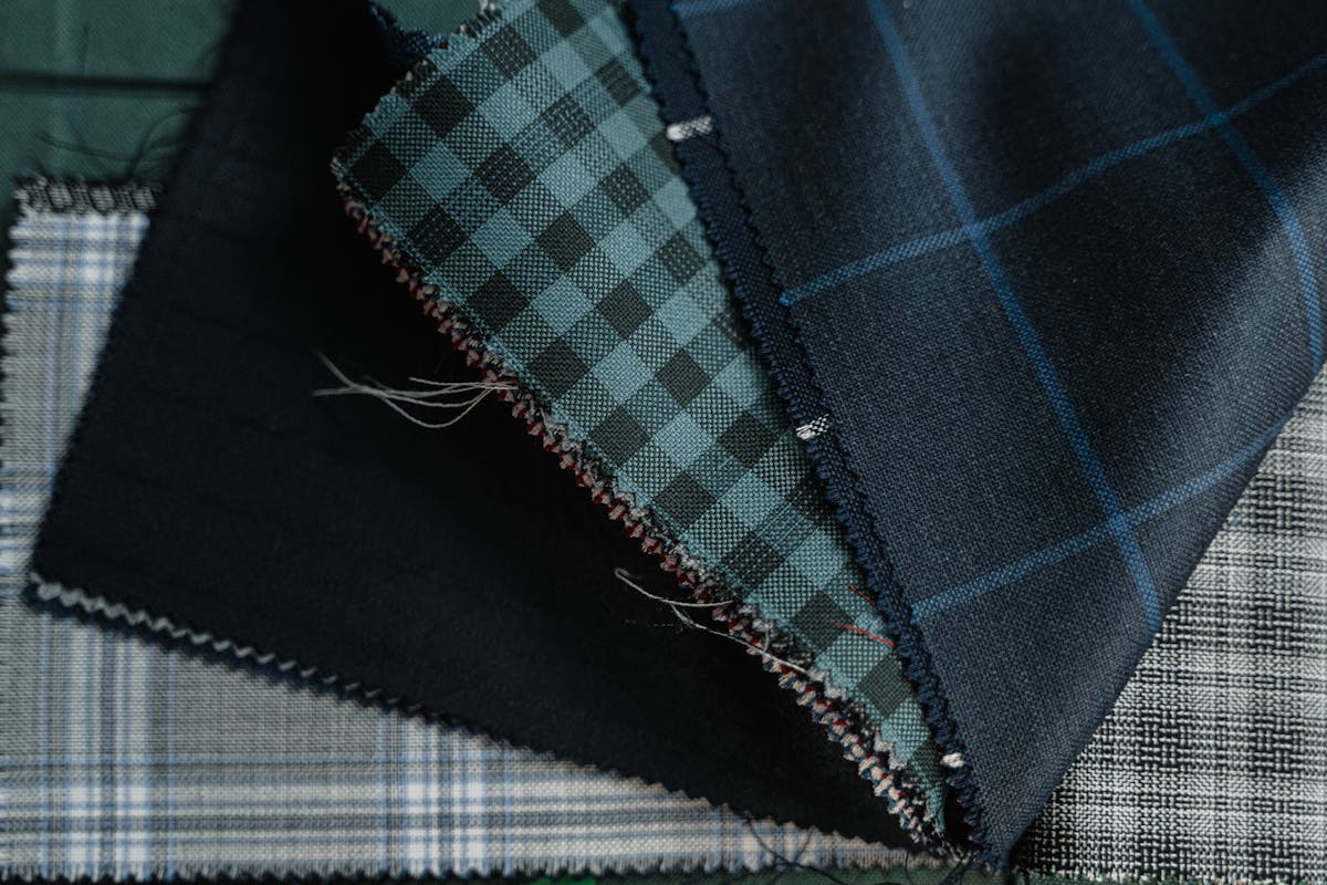 Close-up of folded wool suiting fabric swatches in grey and navy with visible weave