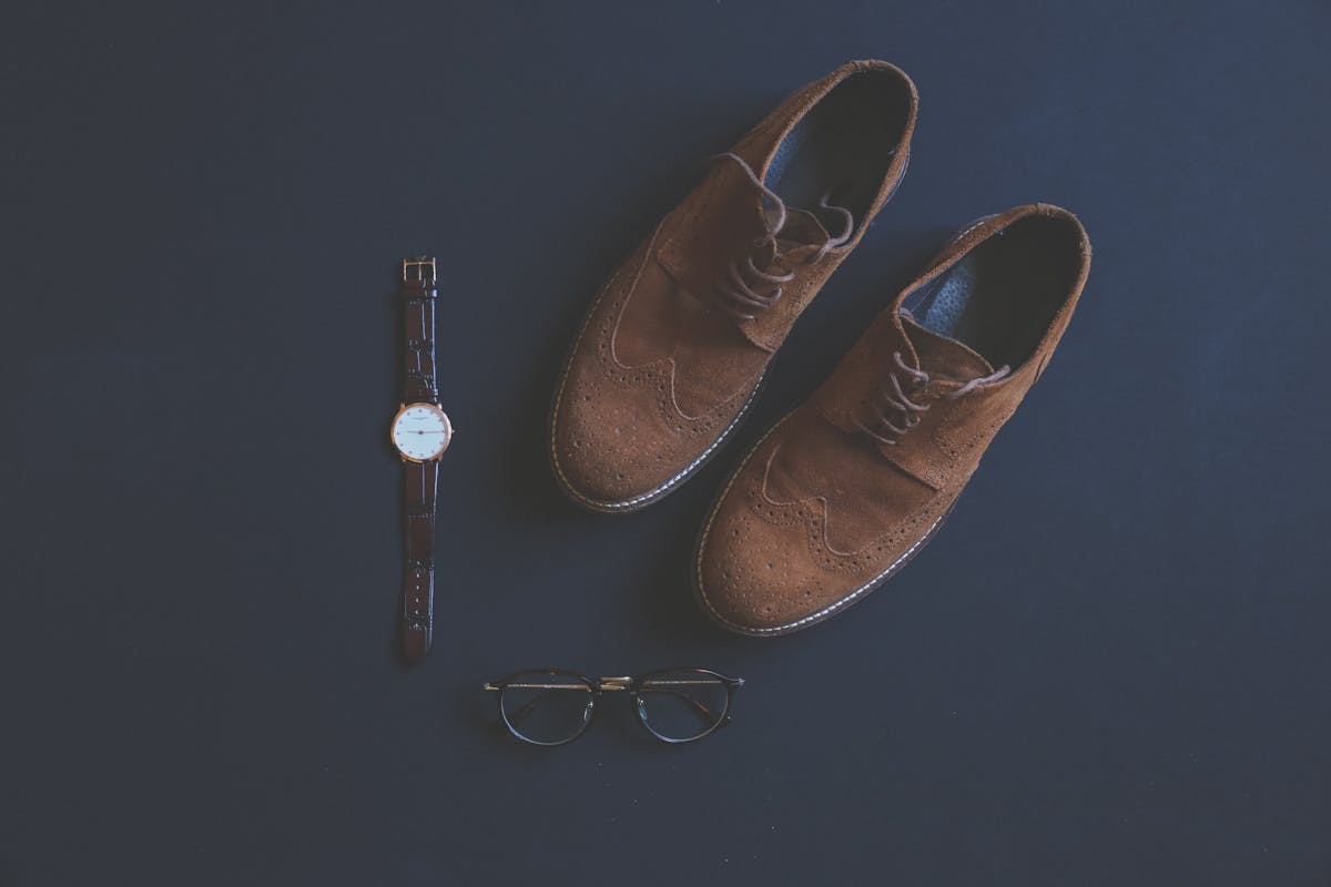 Flat-lay of a complete Kentucky Derby men's outfit — straw hat, pastel jacket, bow tie, pocket square, sunglasses and brown loafers laid out for Derby day