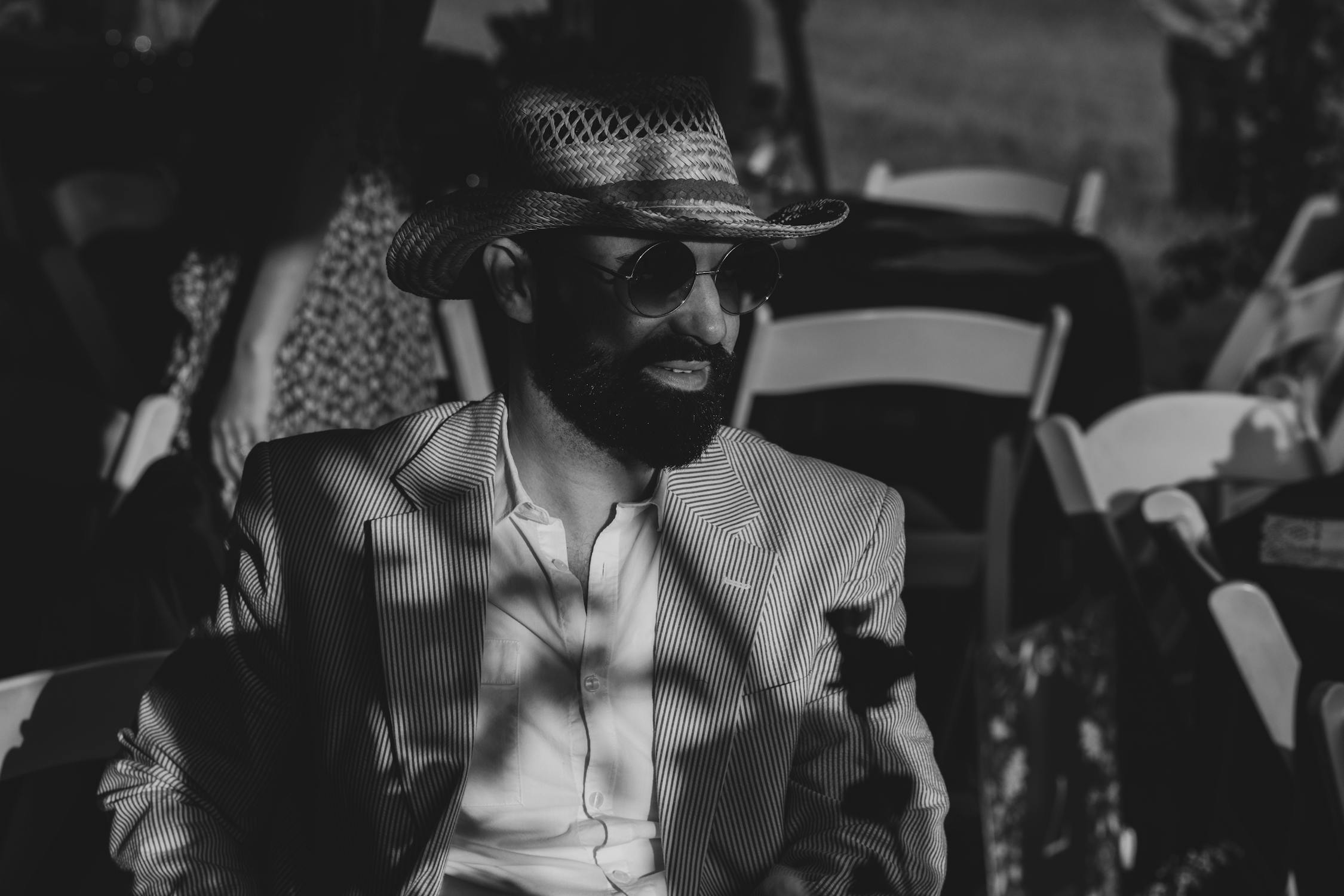 Man in a straw hat and striped blazer at an outdoor event -- the quintessential Derby look combines bold patterns with summer sophistication