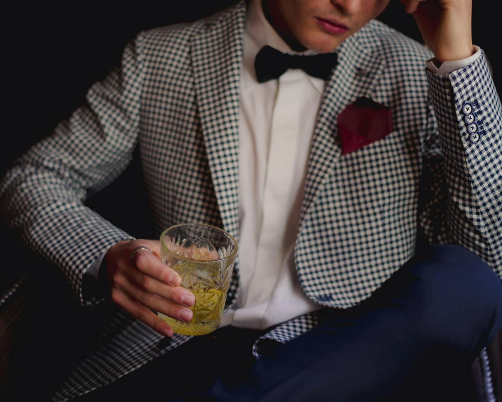 A light seersucker suit with a pink pocket square and a Panama hat on a wooden bench -- the uniform of Oaks Day at Churchill Downs