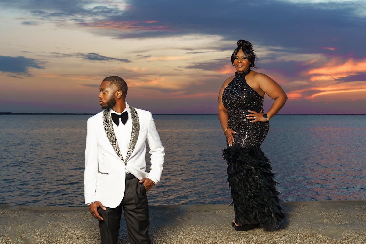 Couple in an all-black formal look, black suit and black dress, photographed like a movie premiere