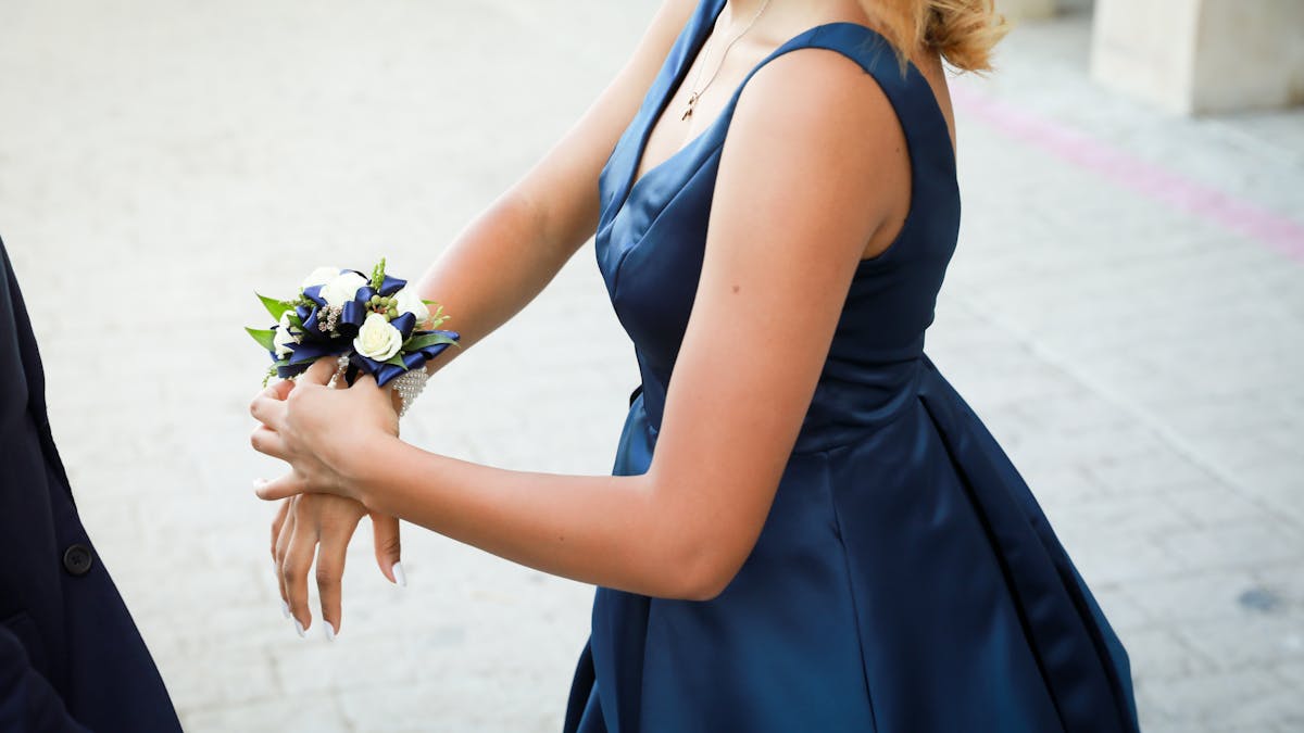 Couple in coordinated formal attire posing together at prom