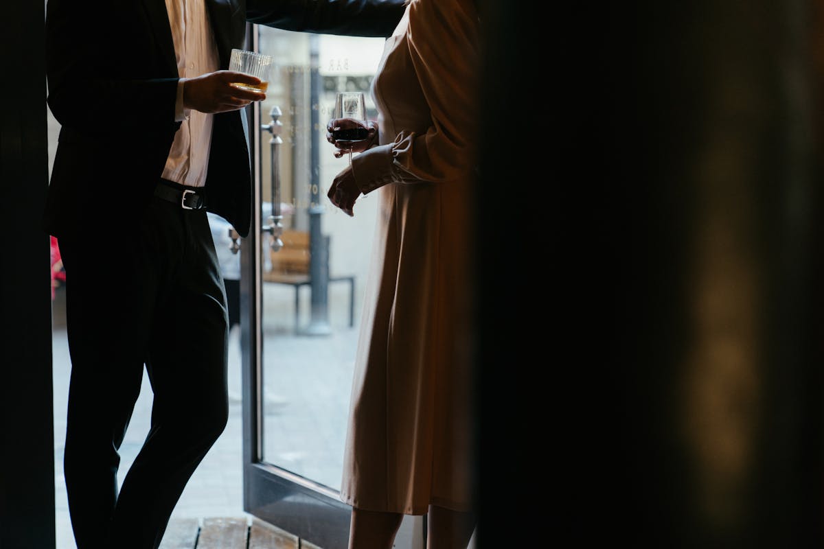 Two people both in tailored suits coordinating with contrasting neutral colors and a shared accent