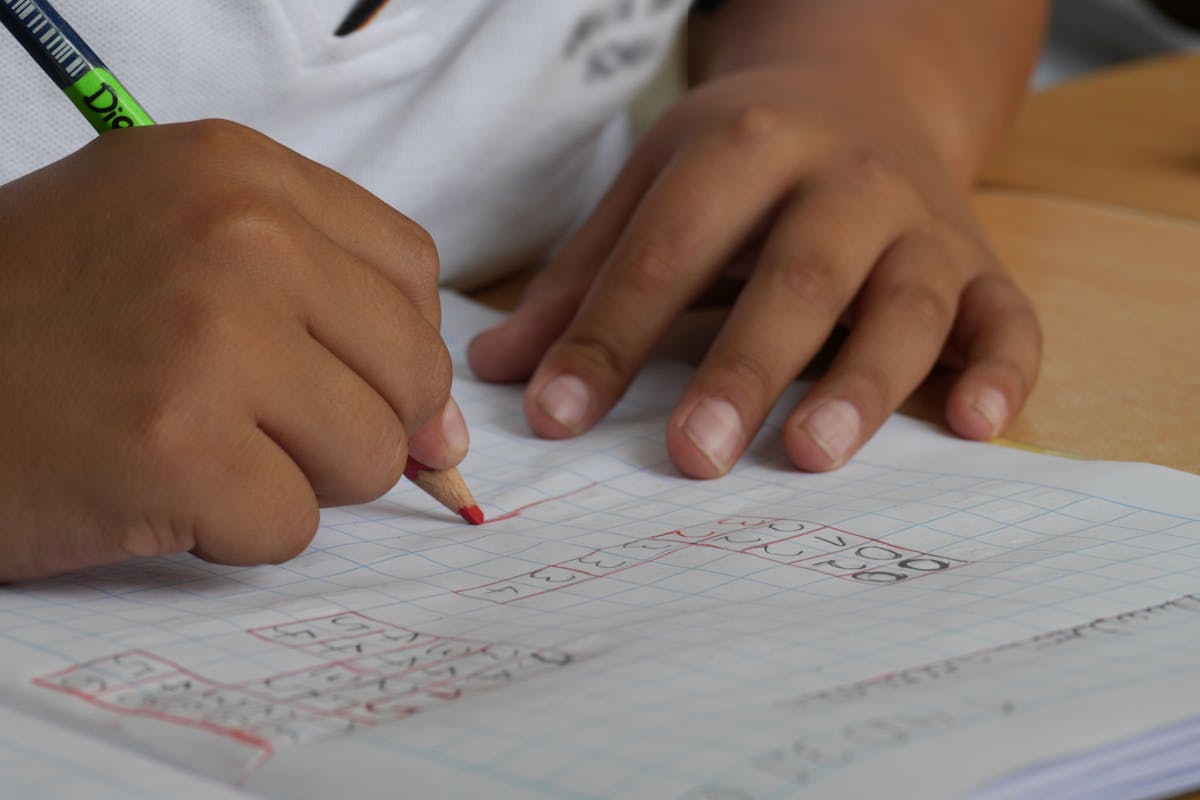 Hand writing measurements in a small notebook next to a coiled tape measure