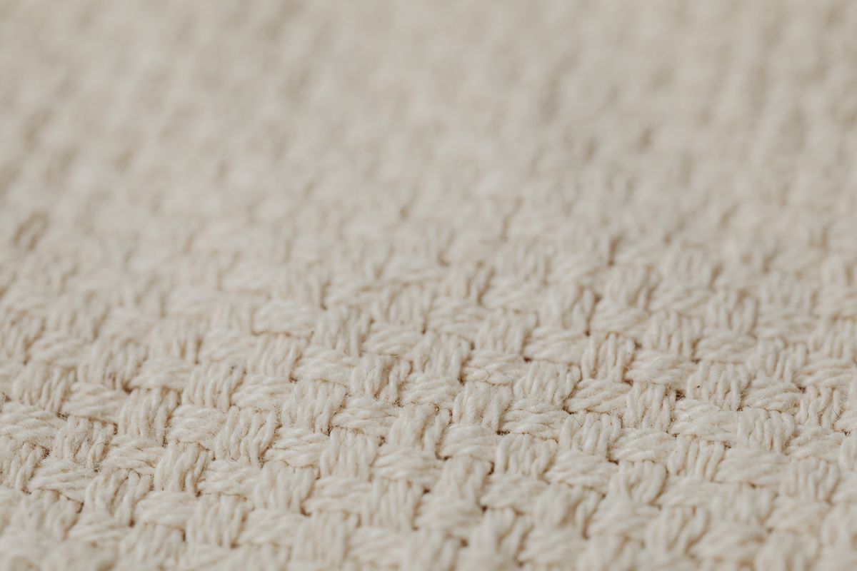 Close-up of linen and lightweight wool suiting fabrics in navy and grey, showing weave and texture differences