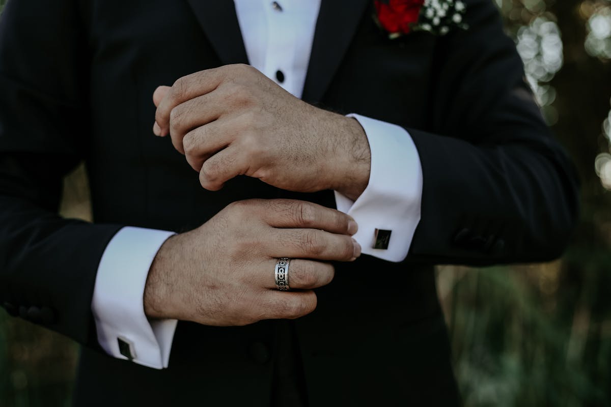 A dark suit sleeve with a red band tied above the elbow against a plain background