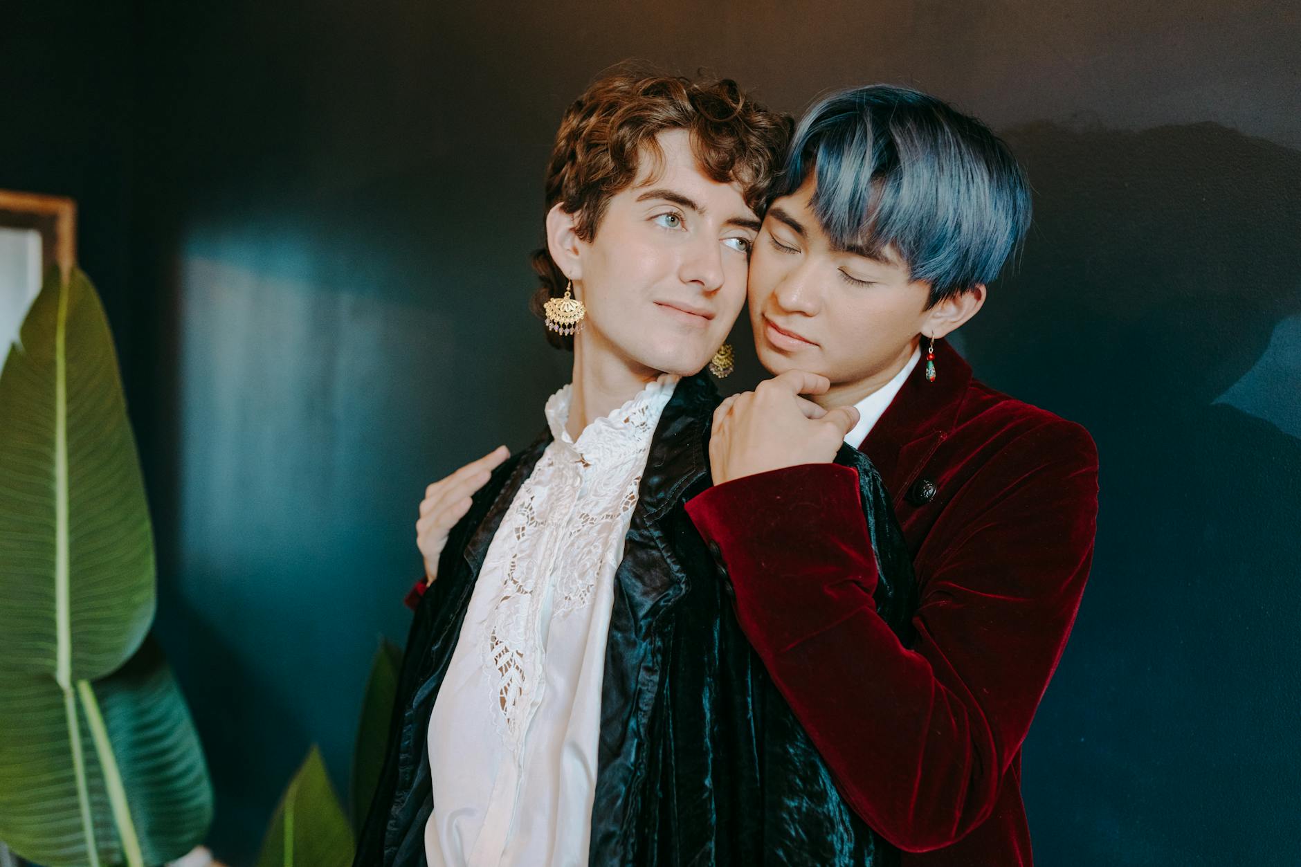 Young man in an emerald green velvet dinner jacket with black trousers and a bow tie, standing against a warm studio background -- the defining prom 2026 boys look