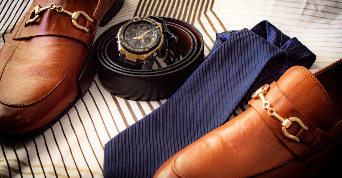Close-up of men's prom accessories including dress shoes, tie, and pocket square arranged on a dark surface