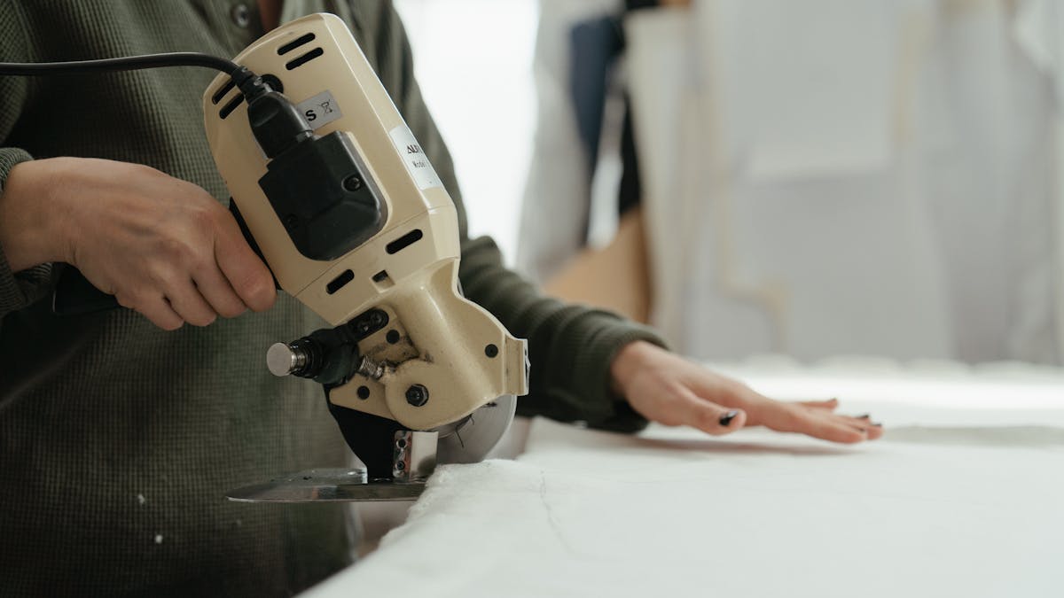A skilled tailor hand-sewing a custom garment in a workshop