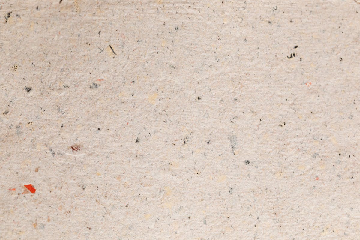 Stacked swatches of textured suiting cloth including flecked tweed and rumpled linen, the fabric textures the model rendered convincingly when given weight and weave